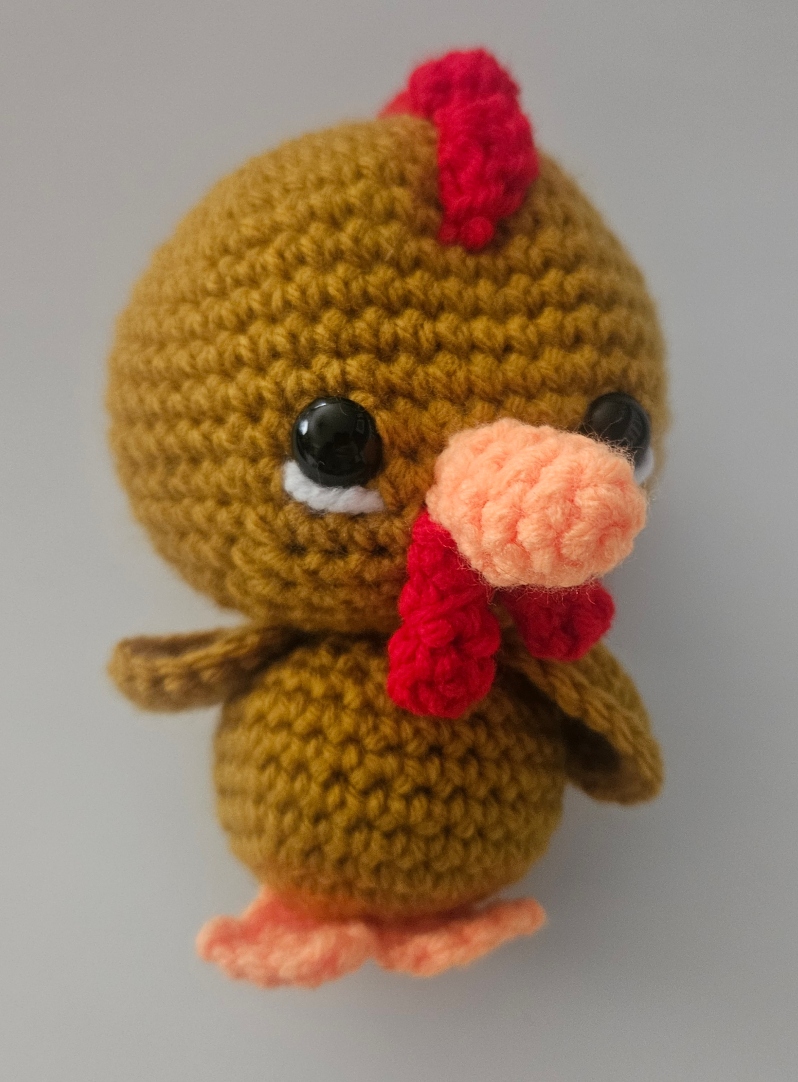 Product Description: Materials used: Yarn, Polyfil, Safety Eyes</br></br>Dimensions: 4wx6hx4d inches</br>Cute amigurumi character. Unique gift for family and pets. Available in chicken, duck, mallard.</br></br>Artist Statement: Crochet is one of my favorite mediums for artistic expression, where yarn and a hook become the tools through which I craft whimsical characters and imaginative worlds. With each stitch, life is given to these soft sculptures, transforming simple materials into endearing creatures. My work in Amigurumi crochet is a testament to the power of handmade artistry, as each piece has their own unique personality and charm. Through this craft, I seek a sense of wonder, joy, and nostalgia in those who encounter my creations, inviting them to embrace the magic of the handmade and the infinite possibilities of yarn.</br></br>Bio: Casey Lucas is a versatile artist with a background in both dance and visual arts. She earned her Bachelor of Fine Arts (BFA) in Dance from Mason Gross School of the Arts and a Master of Fine Arts (MFA) in Art - Ceramics from Kean University. Casey's artistic journey spans various creative mediums, including Amigurumi crochet and ceramics, through which she brings her unique vision to life. After living in New York City for over a decade, she currently resides in the picturesque town of Princeton, New Jersey. Casey shares her life with her husband and two children, drawing inspiration from the town's historic charm. Her work beautifully combines the tactile and visual arts, creating a seamless fusion of movement, texture, and form. Whether through the fluidity of dance or the intricacies of crochet and ceramics, Casey's artistry is a testament to her unwavering commitment to the creative process. Beyond her artistic pursuits, Casey is a recent breast cancer survivor, showcasing incredible resilience and strength throughout her personal journey. She has chosen to use her art as a force for good, dedicating a portion of her sales to support cancer research. Her work not only embodies creativity and passion but also carries a profound message of hope and determination.</br></br>$20 *</br>Price subject to sales tax.</br></br>Item Number: CL55</br> Amigurumi Farm Kingdom by Casey Lucas