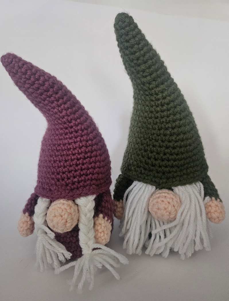 Product Description: Materials used: Yarn, Polyfil, Safety Eyes</br>Available in two different colors.</br></br>Dimensions: 4wx9hx4d inches</br>Cute amigurumi character. Unique gift for family and pets.</br></br>Artist Statement: Crochet is one of my favorite mediums for artistic expression, where yarn and a hook become the tools through which I craft whimsical characters and imaginative worlds. With each stitch, life is given to these soft sculptures, transforming simple materials into endearing creatures. My work in Amigurumi crochet is a testament to the power of handmade artistry, as each piece has their own unique personality and charm. Through this craft, I seek a sense of wonder, joy, and nostalgia in those who encounter my creations, inviting them to embrace the magic of the handmade and the infinite possibilities of yarn.</br></br>Bio: Casey Lucas is a versatile artist with a background in both dance and visual arts. She earned her Bachelor of Fine Arts (BFA) in Dance from Mason Gross School of the Arts and a Master of Fine Arts (MFA) in Art - Ceramics from Kean University. Casey's artistic journey spans various creative mediums, including Amigurumi crochet and ceramics, through which she brings her unique vision to life. After living in New York City for over a decade, she currently resides in the picturesque town of Princeton, New Jersey. Casey shares her life with her husband and two children, drawing inspiration from the town's historic charm. Her work beautifully combines the tactile and visual arts, creating a seamless fusion of movement, texture, and form. Whether through the fluidity of dance or the intricacies of crochet and ceramics, Casey's artistry is a testament to her unwavering commitment to the creative process. Beyond her artistic pursuits, Casey is a recent breast cancer survivor, showcasing incredible resilience and strength throughout her personal journey. She has chosen to use her art as a force for good, dedicating a portion of her sales to support cancer research. Her work not only embodies creativity and passion but also carries a profound message of hope and determination.</br></br>These are sold individually.</br>$18 each*</br>Price subject to sales tax.</br></br>Item Number: CL56</br> Amigurumi Gnome by Casey Lucas